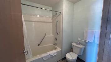 Bañera con ducha, toallas, jabón, shampoo