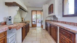 A kitchen with wooden cabinets, a tiled backsplash, and a window.