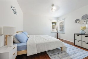 A bedroom with a bed, bedside table, lamp, and a view of the outdoors through a window. - Private 3 Units| 5 Beds | Close to Beach & Bars (San Diego)