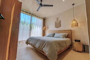 A bedroom with a bed, ceiling fan, wall art, and a bedside lamp. - Serene 2BR Apartment with Private Pool, Kokoon Pueblo II (Tulum)