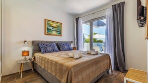 A bedroom with a bed, a bedside table, a lamp, a painting, and a window with curtains. - Istriensonne 0785 - Newly built semi-detached house Double1 with private pool (Loborika)
