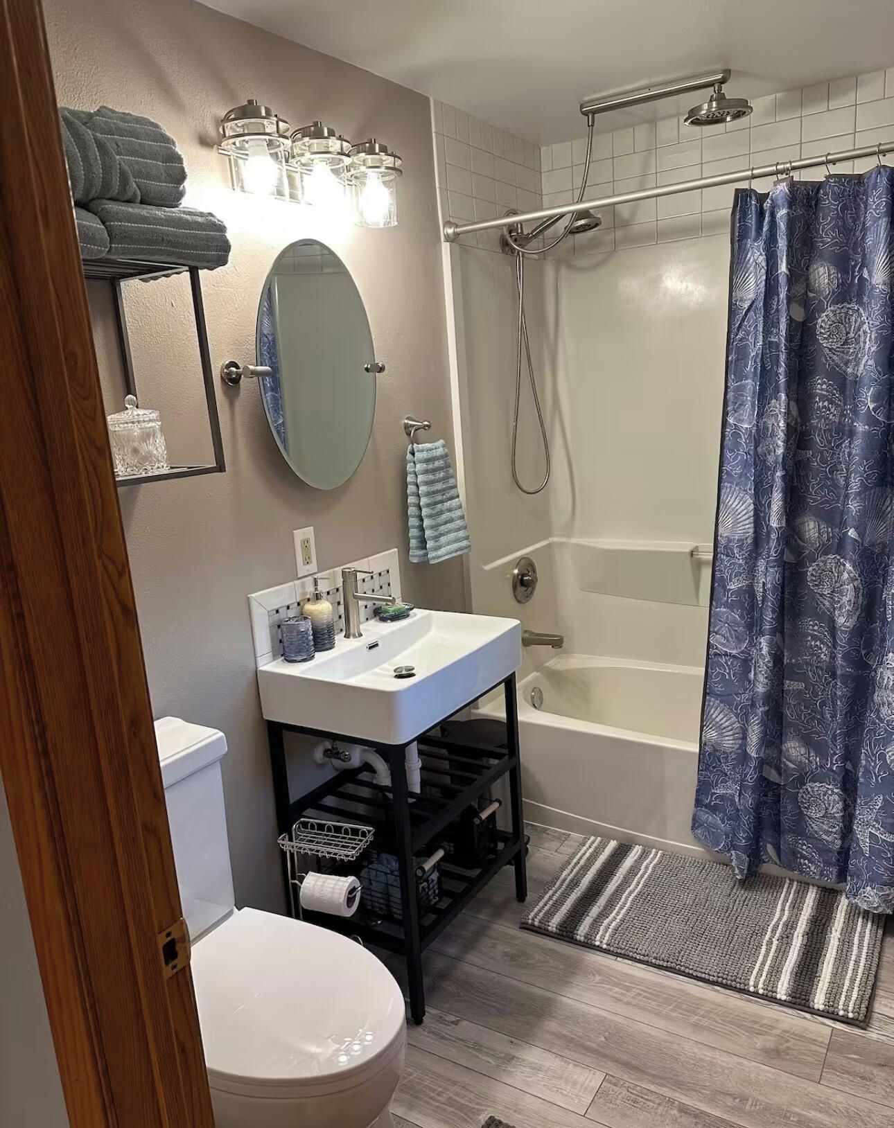 A full bathroom with a toilet, sink, mirror, and bathtub.