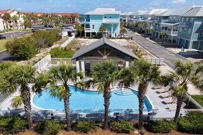 A resort with a swimming pool surrounded by palm trees, a covered pavilion, and beachfront buildings. - Camp David 🌅 Soundside Escape in Gated Community | Pool + Hot Tub (Navarre)
