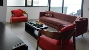 A modern living room with a sofa, armchair, and coffee table. - Apartment Ocean Side View Poseidon Building (Manta)