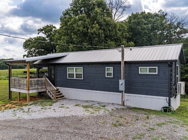 A small, single-story building with a porch and a covered deck area.