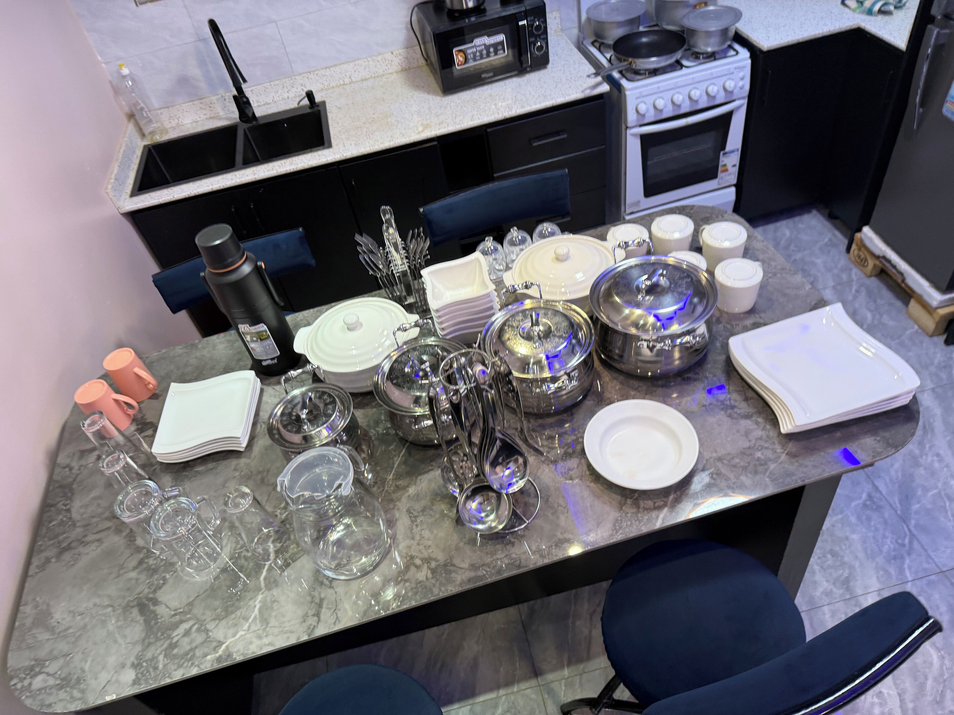 A kitchen with a stove, microwave, and various kitchenware.