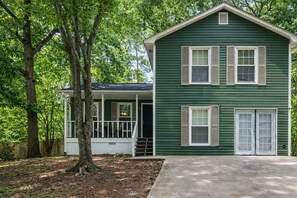 A two-story house with a porch, a garage, and a driveway. - King Bed/ 2 Living-rooms/ Patio/ BBQ Grill (Norcross)
