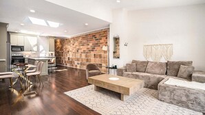 Un espacio moderno de estar con cocina, comedor y zona de descanso.