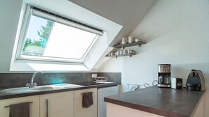 Eine Küche mit Oberlicht, Kaffeemaschine und Wasserkocher auf der Arbeitsplatte.