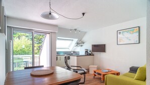 Ein gemütlicher Wohnbereich mit Essplatz, Küchenzeile und einer Couch.