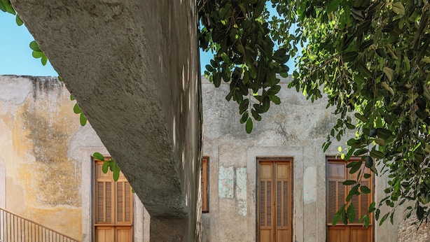 A courtyard with a pool, stone walls, wooden shutters, and a staircase. - Hotel Sevilla (Mérida)
