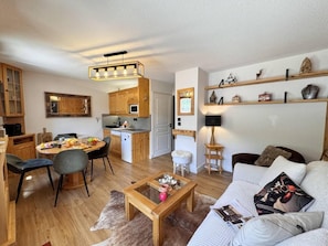 Ein gemütliches Wohnzimmer mit einer Couch, einem Couchtisch und einem Essbereich mit Stühlen und einem Tisch.