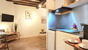 Une cuisine compacte équipée d’un évier, d’une cuisinière et d’un coin repas avec une table et des chaises.