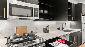 A modern kitchen with a built-in stove, microwave, and sink. - Amazing Studio | King Bed | Walk to Raymond James! (Tampa)