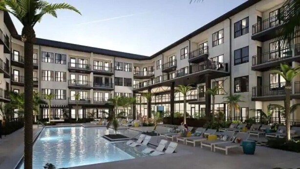 A multi-story hotel with a central pool area, outdoor seating, and balconies. - Stylish & Clean Oasis | City Center | Pool & Gym (Tampa)