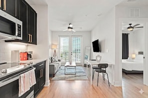 Quarto de hotel moderno com cozinha, área de refeições, sala de estar e quarto.