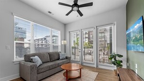 A modern living room with a gray sofa, a wooden coffee table, and a ceiling fan.