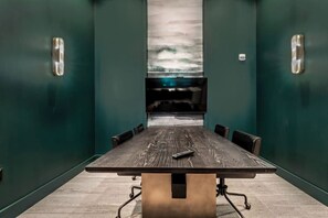 A conference room with a long table, chairs, and a TV screen on the wall. - The Perfect 2BD in Channelside District! (Tampa)