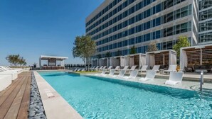 Una piscina con sillas de descanso y una terraza de madera.