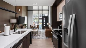Una cocina moderna con una isla central, electrodomésticos integrados y un comedor con vistas.