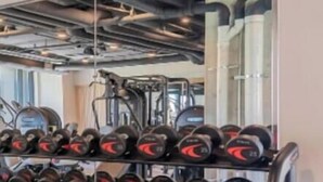 Une salle de sport équipée de matériel de musculation, notamment des haltères et un banc.