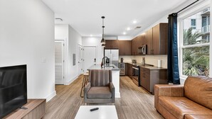 A modern apartment with a living room, kitchen, and dining area. - Upscale 2BR Stay | Minutes from Convention Center (Tampa)