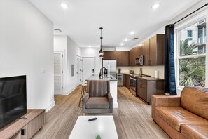 A modern apartment with a living room, kitchen, and dining area.