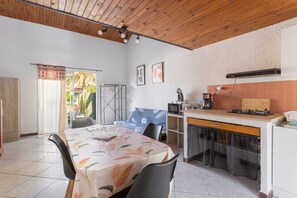 Une cuisine de taille réduite avec un coin repas, un plafond en bois et des murs carrelés.