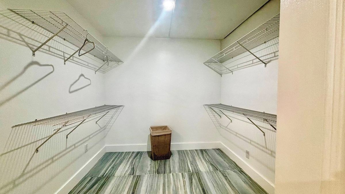 A laundry room with metal drying racks and a wooden basket.