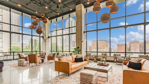 A spacious lobby with large windows, leather sofas, and a modern chandelier. - A+ Spacious Luxury 2BR | Pool+Lounge+Parking (Indianapolis)