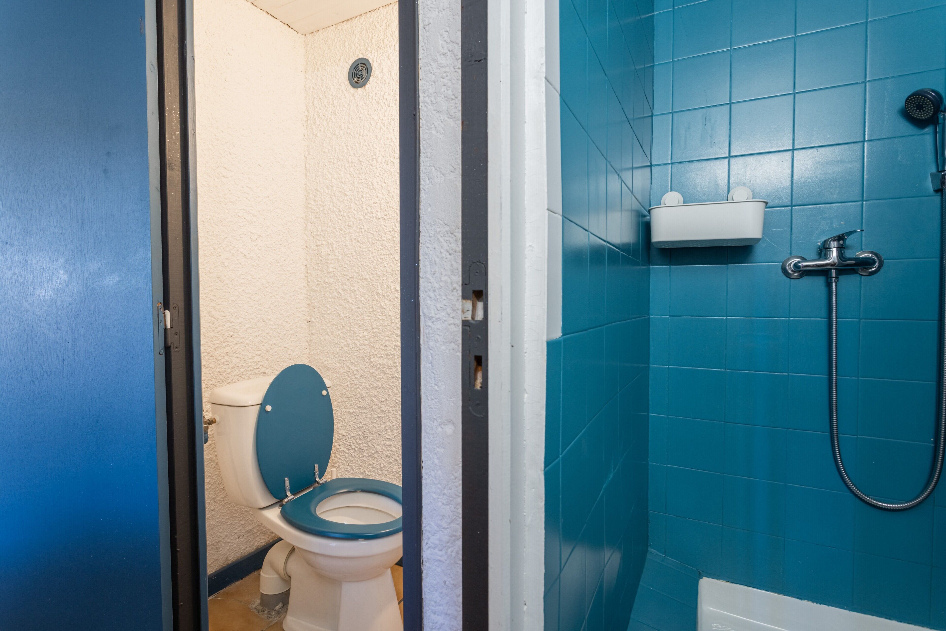 A bathroom with a toilet, a shower, and a sink.