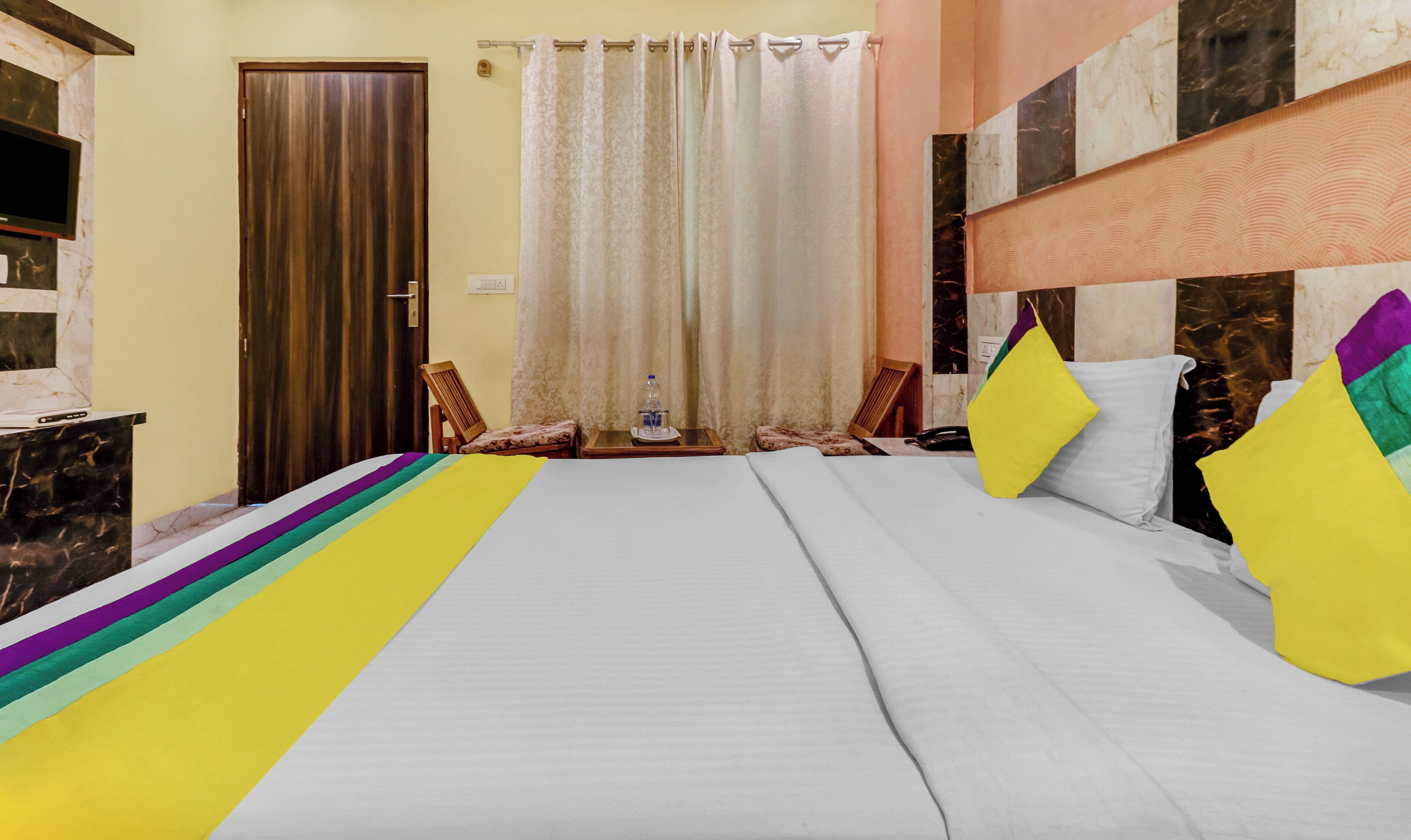 Quarto de hotel com uma cama grande, uma escrivaninha e uma cadeira.