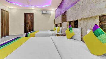A hotel room with two beds, a ceiling fan, an air conditioning unit, and a marble-patterned wall.