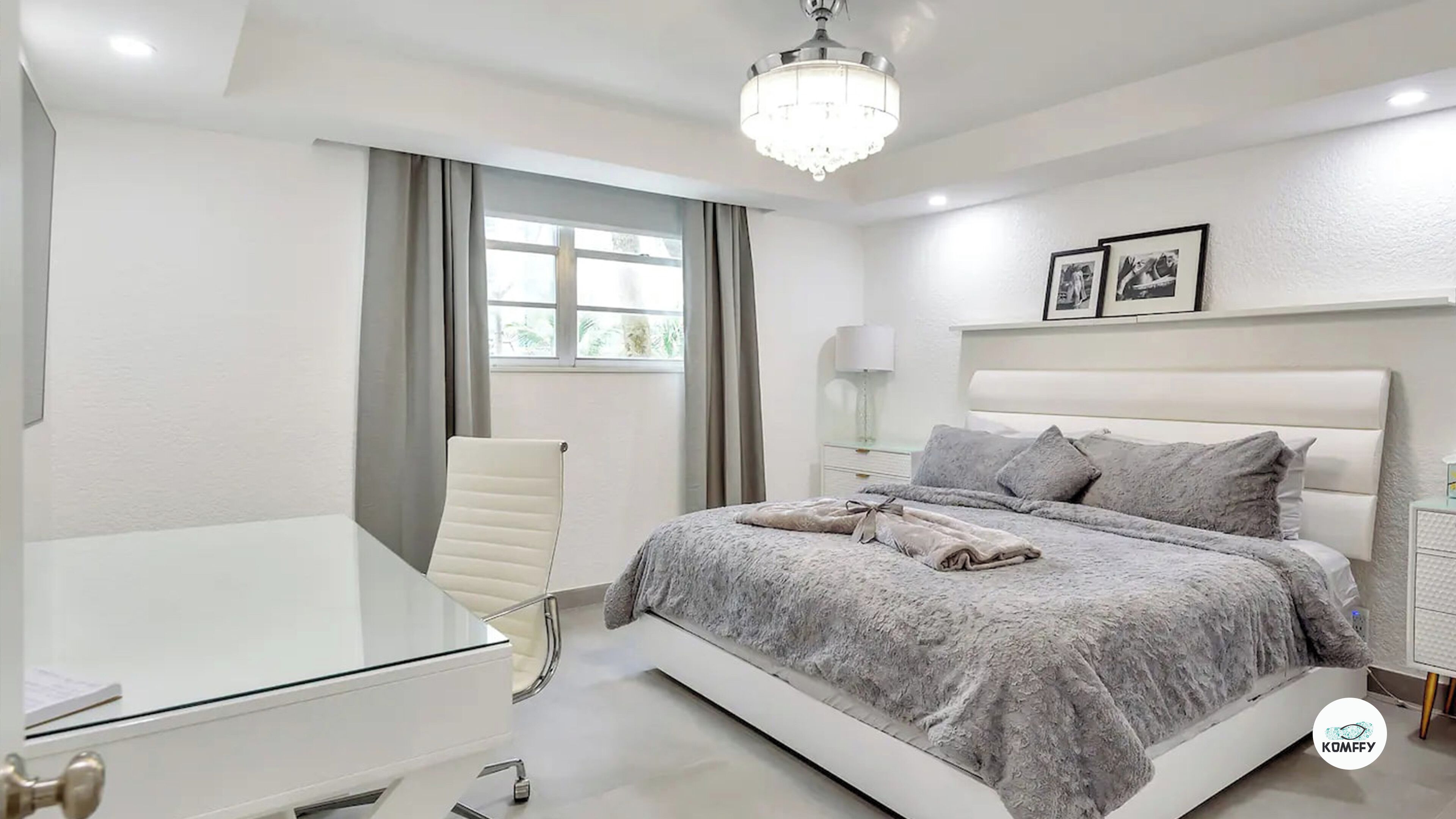 A modern bedroom with a large bed, a bedside table, a chair, and a desk.
