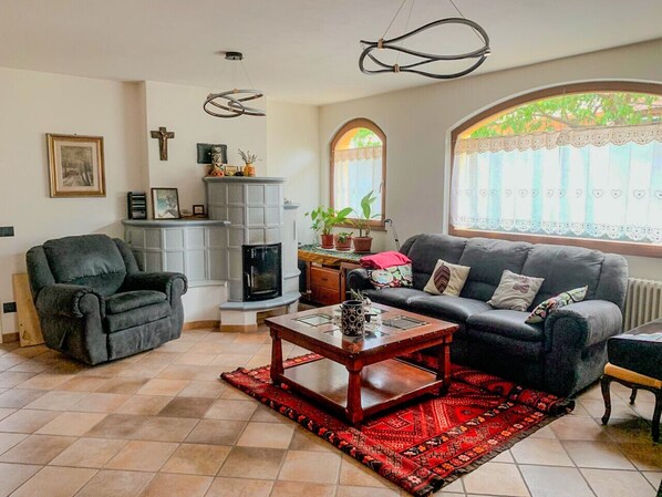 A cozy living room with a fireplace, a sofa, a chair, and a coffee table.