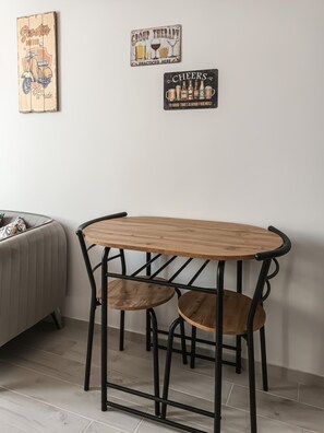 Een eetgedeelte met een houten tafel en zwarte metalen stoelen.