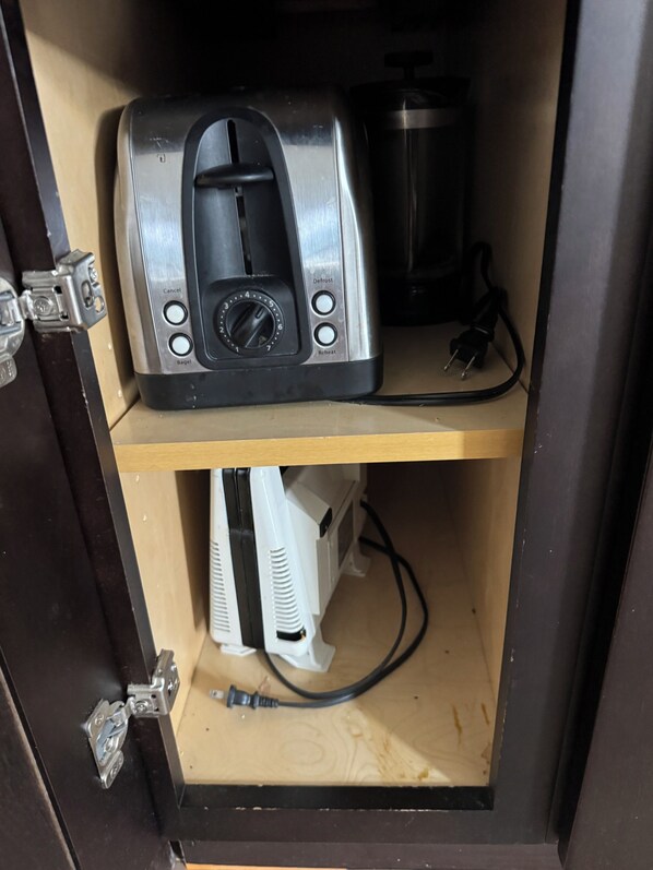 Una cucina con un tostapane sullo scaffale superiore e un elettrodomestico bianco sullo scaffale inferiore.