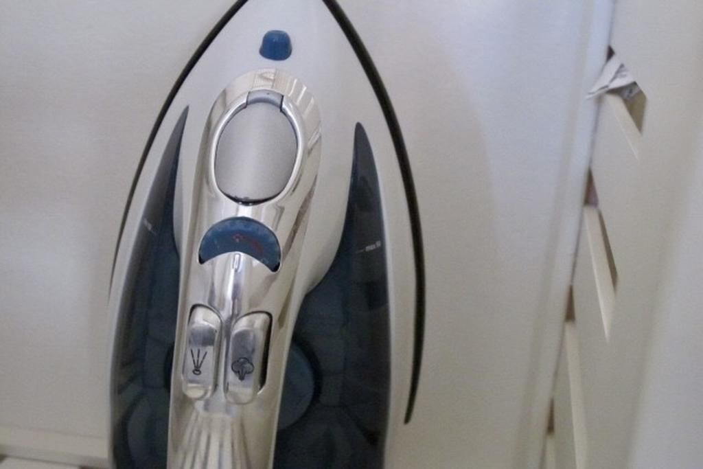 Gros plan d’un objet métallique de forme ovale, doté d’un bouton circulaire et d’un indicateur lumineux bleu.