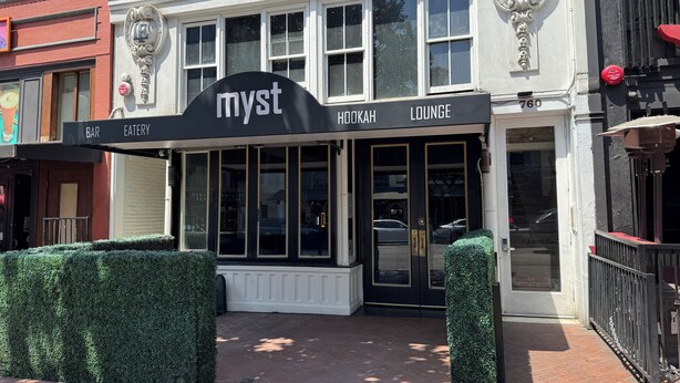 A building with a sign reading "Myst Hookah Lounge" and a bar/restaurant sign above it.