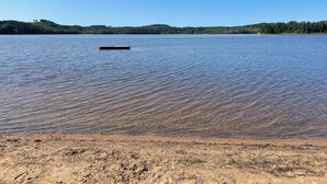 A sandy beach with a small dock extending into calm water. - Farm idyll with lake views, private beach spot & boat near the west coast (Västra Götalands län)