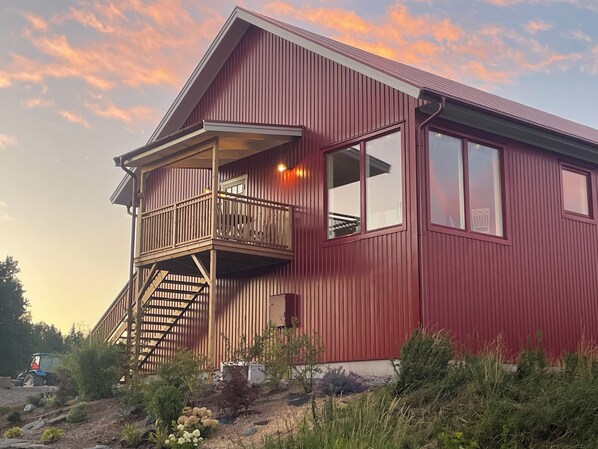 A two-story building with a balcony and a staircase leading to the upper floor. - Peaceful Farm Stay with Lake Views, Sandy Beach & Boat (Västra Götalands län)