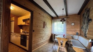 A wooden interior with a kitchen, dining area, and seating. - Urlaubsstube1982 - wildly romantic with a fireplace and rustic charm (Schöfweg)