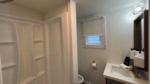 Un bagno con doccia, toilette e lavandino.