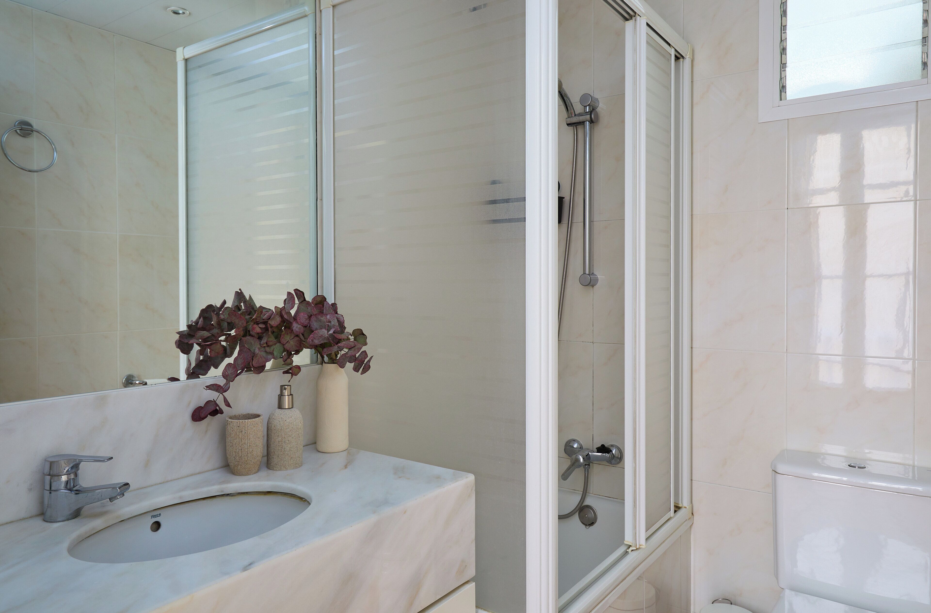 Ein Badezimmer mit Waschbecken, Spiegel und Dusche.