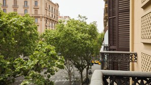 A street view with buildings, trees, and a yellow taxi. - Stay U-nique Apartments Ronda Sant Pere (Barcelona)