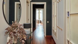 A hallway with a mirror, a vase with dried flowers, and a lamp on a table. - Stay U-nique Apartments Ronda Sant Pere (Barcelona)