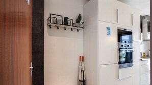 A modern kitchen with white cabinetry, a built-in oven, and a stainless steel refrigerator. - Stay U-nique Apartments Aprestadora (L'Hospitalet de Llobregat)