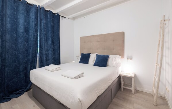 Une chambre à coucher avec un lit, une table de chevet, une lampe et une échelle en bois.