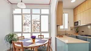 Una cocina moderna con armarios de madera, una isla central y vistas a la ciudad a través de amplias ventanas.