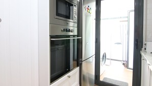 A kitchen with a built-in oven, microwave, and refrigerator. - Stay U-nique Villa Marinada (Calafell)
